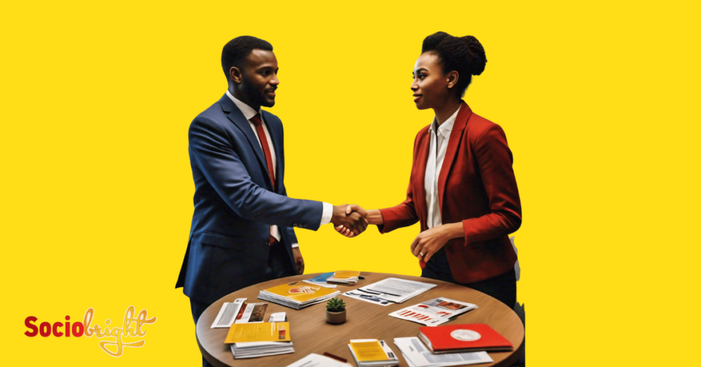 a business person shaking hands with another across a table filled with B2B marketing materials, illustrating the B2B Marketing Conferences 2024.